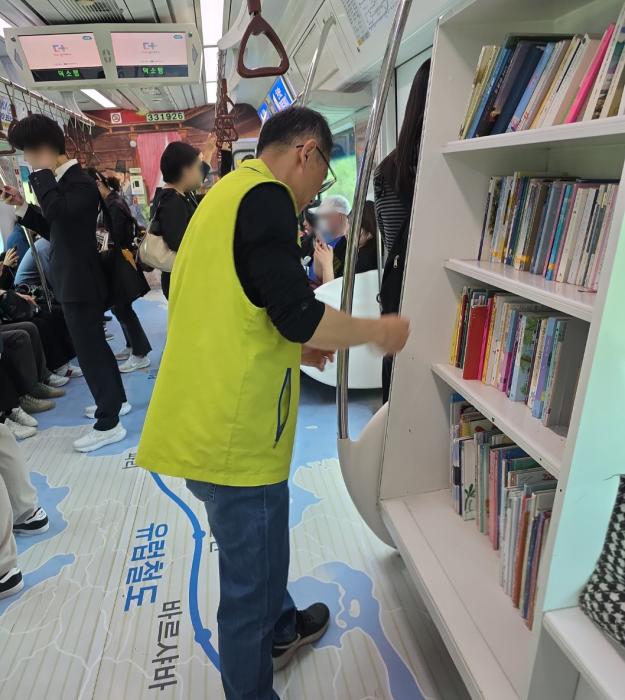 봉사자가 서가를 정리하고 모습 사진 봉사단 제공