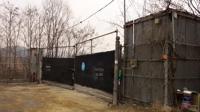  굳게 닫힌 캠프 개리오웬의 문  미군 철수 이후 수십 년간 개발 동력을 찾지 못한 채 방치되어 있는 캠프 개리오웬 정문의 모습 검은 가림막과 녹슨 철조망이 지역 침체의 단면을 보여주고 있다