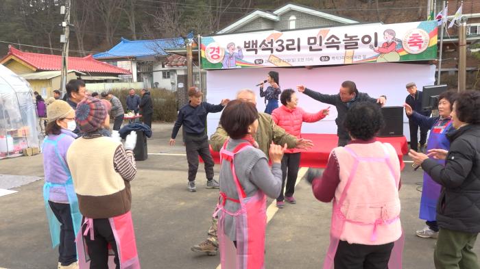 야외 특설 무대에서 초대가수들이 열창하는 가운데 주민들이 무대 앞으로 나와 노래에 맞춰 춤을 추며 축제를 즐기고 있다