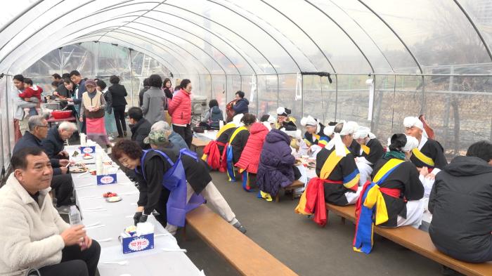 비닐하우스 내 마련된 연회장에서 주민들과 풍물단원들이 정성껏 준비한 음식을 나누며 정을 쌓고 있다